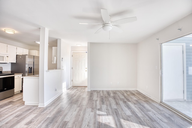 kitchen featuring stainless steel appliances, tasteful backsplash, white cabinets, and light hardwood / wood-style floors