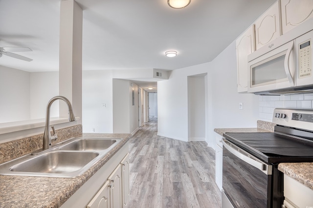 kitchen featuring sink, white cabinets, electric stove, light hardwood / wood-style floors, and backsplash