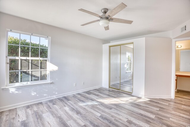 unfurnished bedroom featuring ceiling fan, a closet, and light wood-type flooring