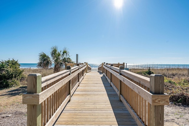 view of property's community with a water view and a beach view