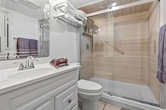 bathroom featuring tile patterned flooring, vanity, toilet, and walk in shower