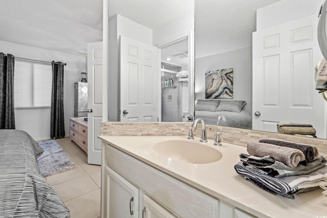 bathroom with tile patterned flooring, vanity, and a textured ceiling