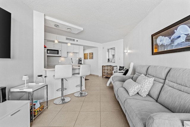 tiled living room featuring a textured ceiling