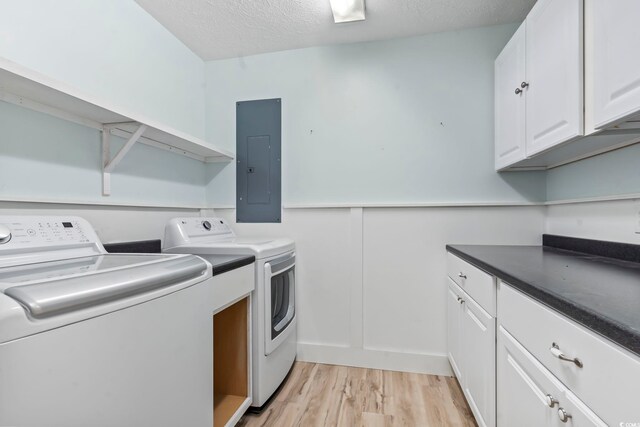 3545 Marion Ln, Murrells Inlet, SC 29576 - washroom featuring electric panel, washer and clothes dryer, light wood finished floors, a textured ceiling, and cabinet space