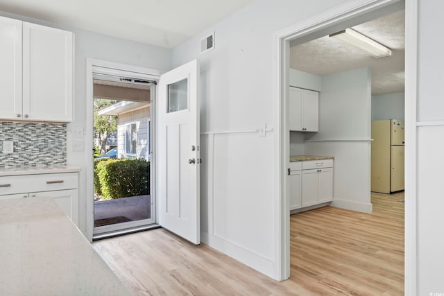 interior space with light hardwood / wood-style flooring and a textured ceiling