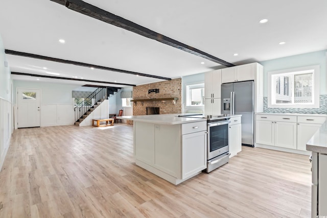 3545 Marion Ln, Murrells Inlet, SC 29576 - kitchen featuring open floor plan, appliances with stainless steel finishes, beam ceiling, light wood finished floors, and wainscoting