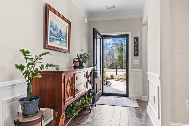 entrance foyer with ornamental molding and dark hardwood / wood-style flooring