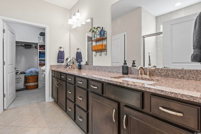 bathroom with walk in shower, tile patterned floors, and vanity