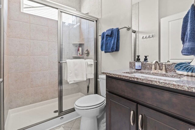 bathroom featuring vanity, tile patterned floors, toilet, and walk in shower