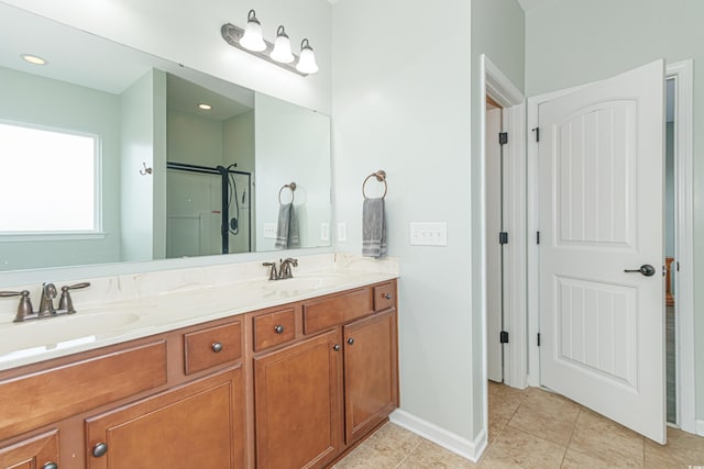 bathroom featuring a shower with door, vanity, and tile patterned floors