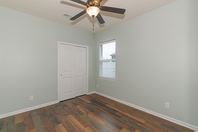 spare room with dark hardwood / wood-style flooring and ceiling fan