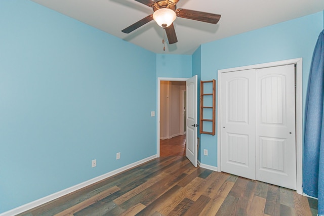 unfurnished bedroom with ceiling fan, dark hardwood / wood-style floors, and a closet