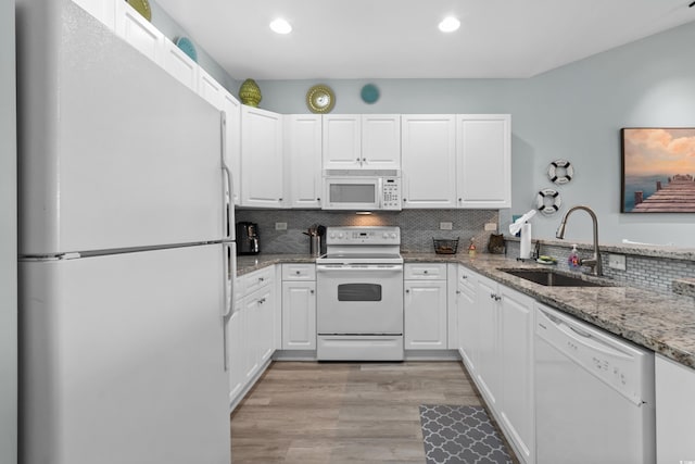 kitchen featuring sink, white appliances, light stone countertops, and white cabinets