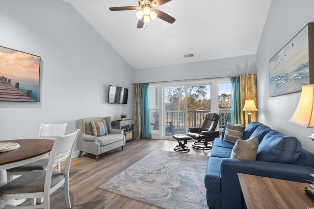 living room featuring ceiling fan, high vaulted ceiling, and light wood-type flooring