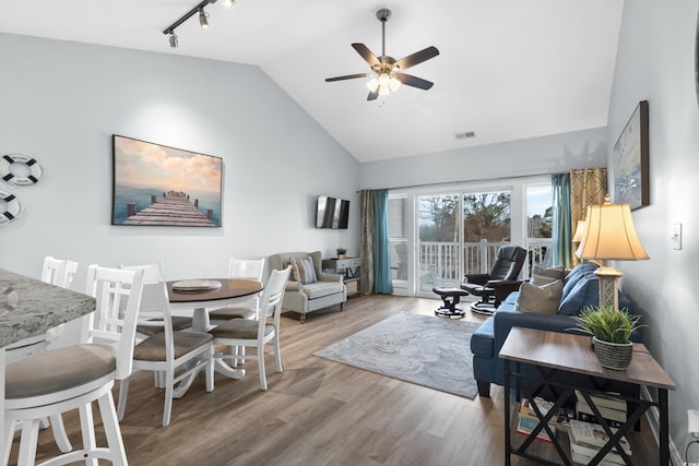 living room with hardwood / wood-style floors, track lighting, high vaulted ceiling, and ceiling fan