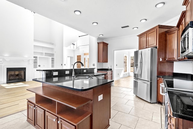 kitchen with sink, crown molding, stainless steel appliances, an island with sink, and light tile patterned flooring