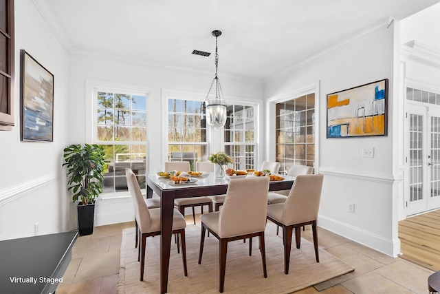 dining space with crown molding, light tile patterned flooring, and a notable chandelier