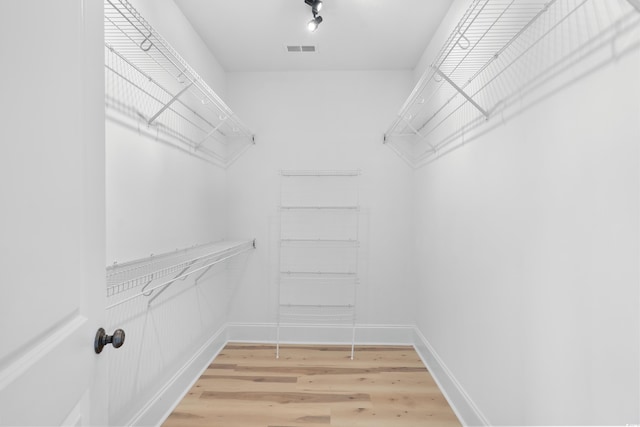 spacious closet with light hardwood / wood-style floors