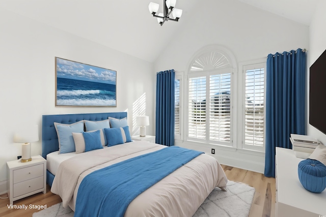 bedroom featuring lofted ceiling, a chandelier, and light hardwood / wood-style flooring