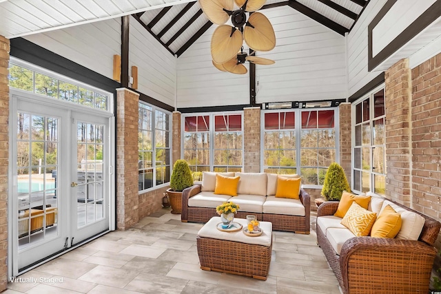 sunroom with ceiling fan and vaulted ceiling