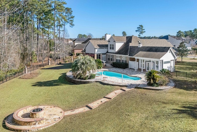 view of swimming pool with a lawn and a fire pit