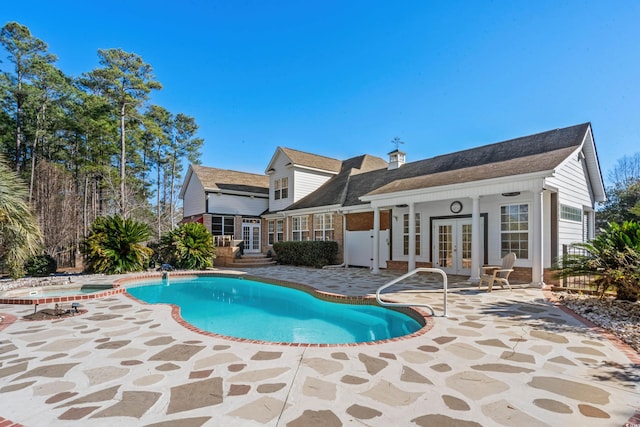 view of swimming pool with a patio area, french doors, and an in ground hot tub