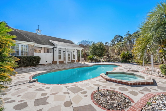 view of pool with an outdoor structure, a patio, and an in ground hot tub