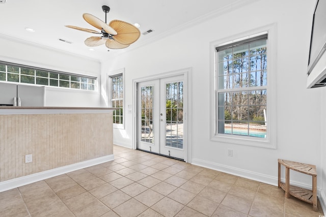 tiled spare room featuring crown molding, french doors, and ceiling fan