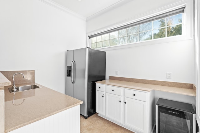 kitchen with sink, crown molding, plenty of natural light, stainless steel refrigerator with ice dispenser, and white cabinets