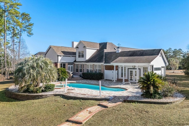 view of swimming pool with french doors, a yard, and a patio