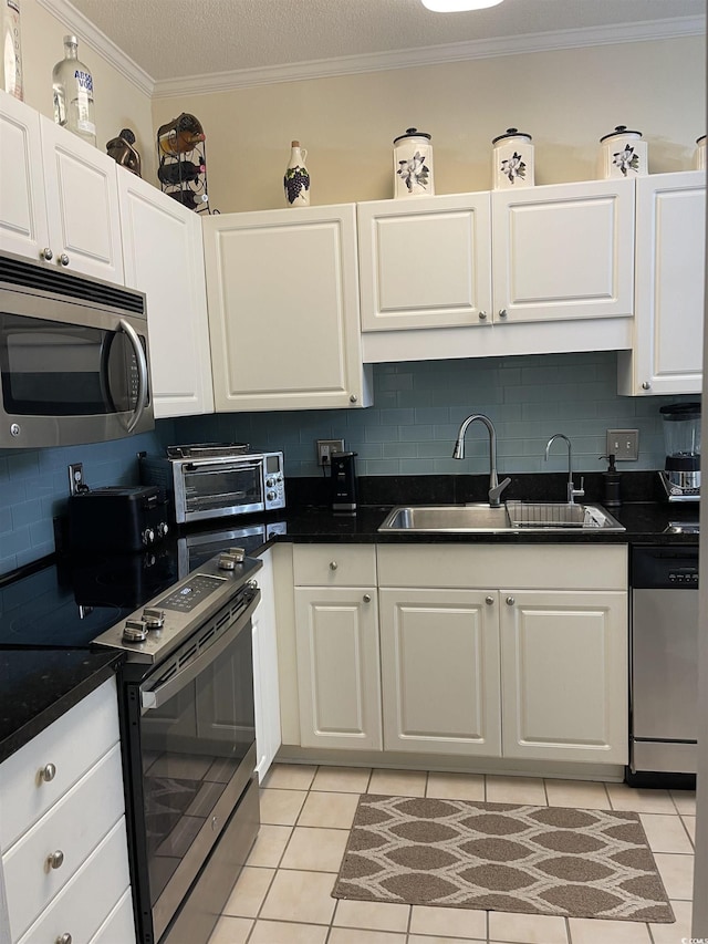 9764 Leyland Dr Unit 7, Myrtle Beach, SC 29572 - kitchen featuring appliances with stainless steel finishes, a sink, light tile patterned floors, backsplash, and white cabinets