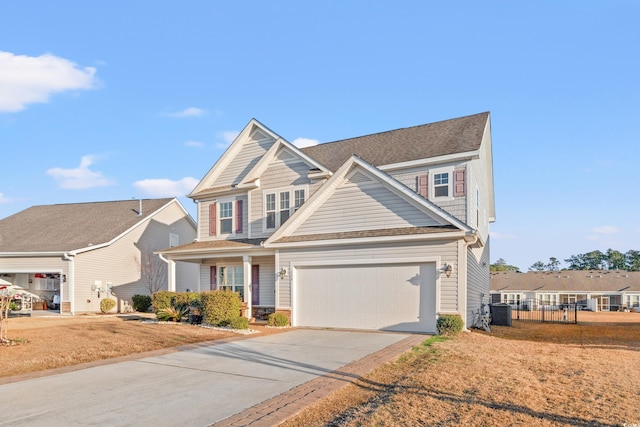 craftsman house featuring a garage, concrete driveway, fence, and central air condition unit