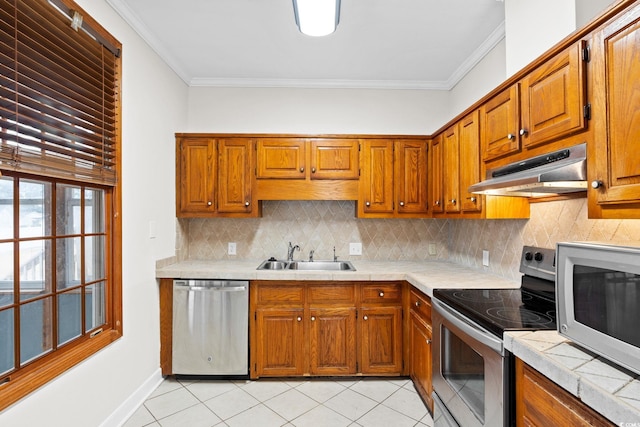 112 Staton Ln, Longs, SC 29568 - kitchen with appliances with stainless steel finishes, under cabinet range hood, crown molding, brown cabinetry, and light tile patterned flooring