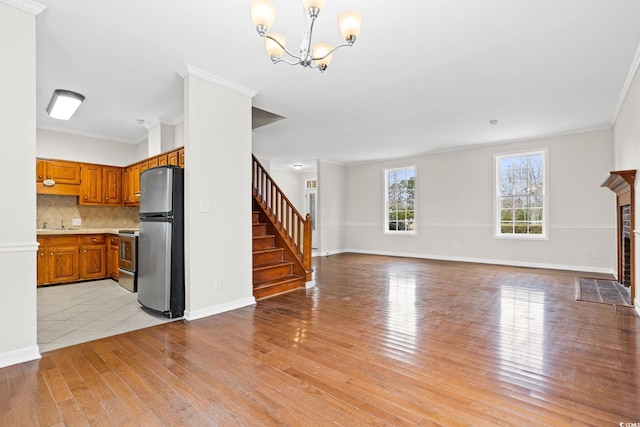 112 Staton Ln, Longs, SC 29568 - unfurnished living room featuring light wood-type flooring, a chandelier, stairway, crown molding, and a fireplace with flush hearth