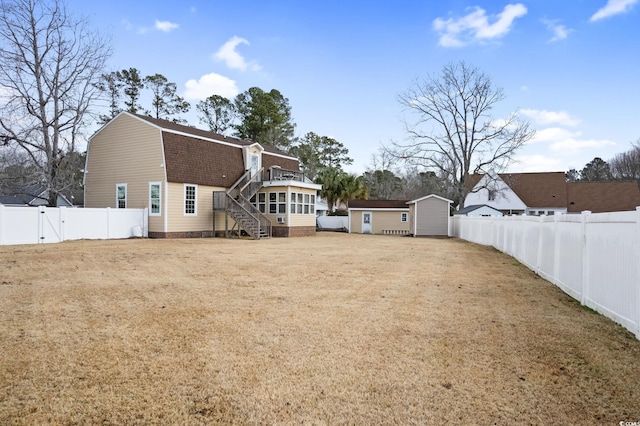112 Staton Ln, Longs, SC 29568 - back of property with a gambrel roof, stairway, a fenced backyard, a storage shed, and a shingled roof
