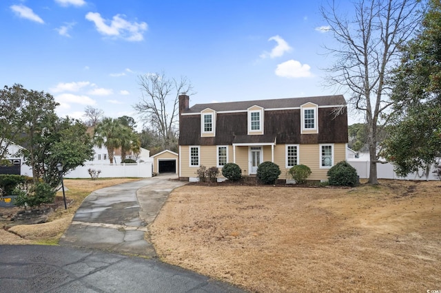 112 Staton Ln, Longs, SC 29568 - colonial inspired home with asphalt driveway, a gambrel roof, an outbuilding, a chimney, and a garage
