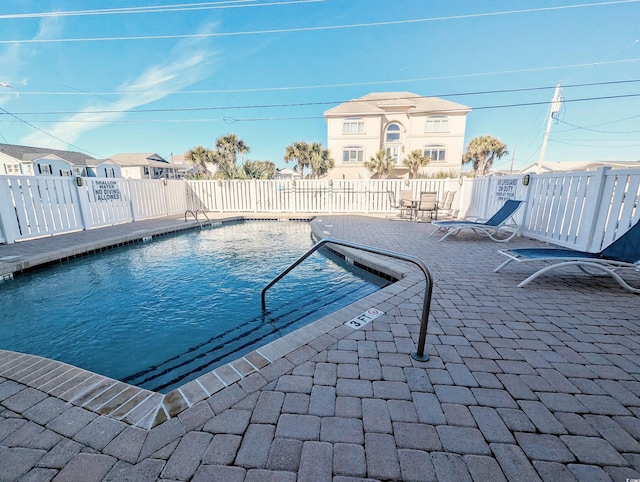 pool with fence and a patio area