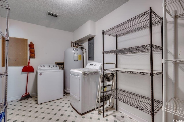 clothes washing area with washing machine and dryer, electric water heater, electric panel, and a textured ceiling