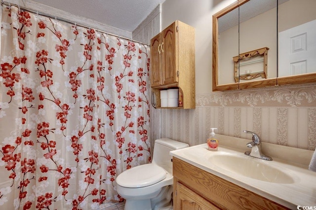 bathroom with a shower with curtain, vanity, a textured ceiling, and toilet