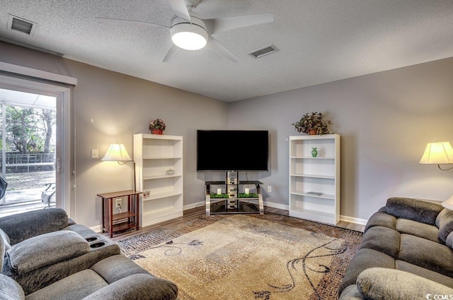 living room with ceiling fan, hardwood / wood-style floors, and a textured ceiling