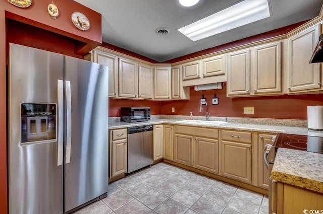 kitchen with stainless steel appliances, light tile patterned flooring, and sink