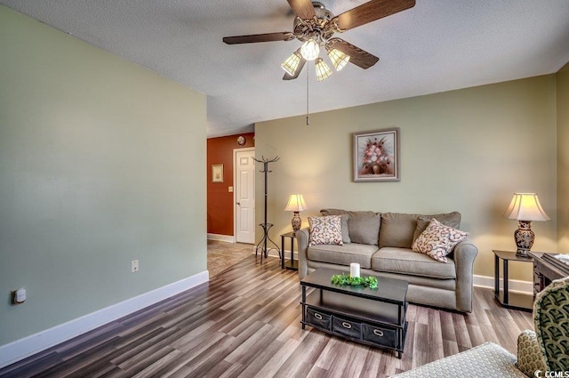 living room with hardwood / wood-style floors, a textured ceiling, and ceiling fan