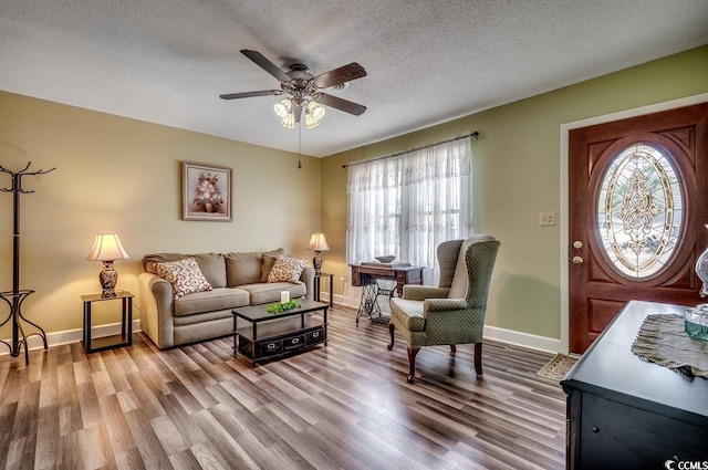 living room featuring hardwood / wood-style floors, a textured ceiling, and ceiling fan