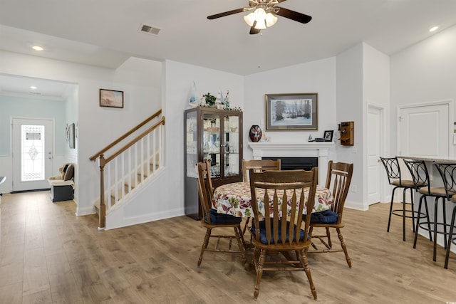 dining space with light hardwood / wood-style flooring, ceiling fan, and vaulted ceiling