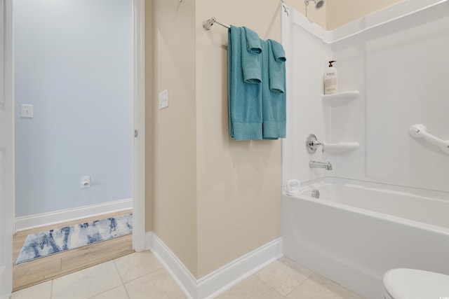 bathroom featuring tile patterned flooring, shower / tub combination, and toilet