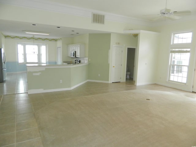 tiled empty room featuring crown molding and ceiling fan