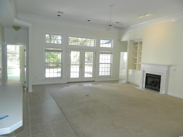 unfurnished living room with ornamental molding, a high end fireplace, built in features, and a wealth of natural light