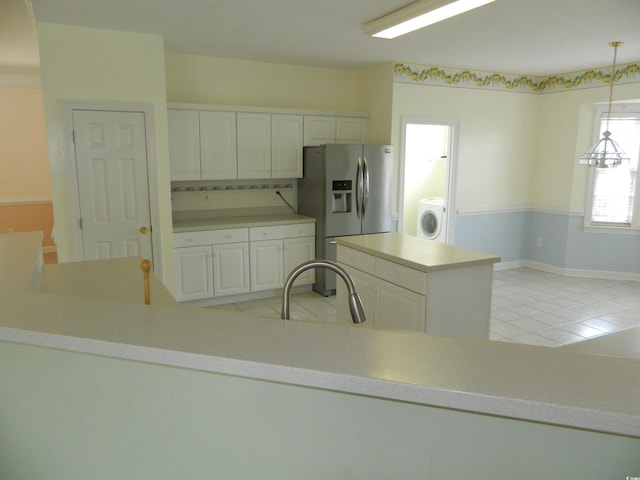 kitchen with sink, hanging light fixtures, stainless steel refrigerator with ice dispenser, white cabinets, and washer / clothes dryer