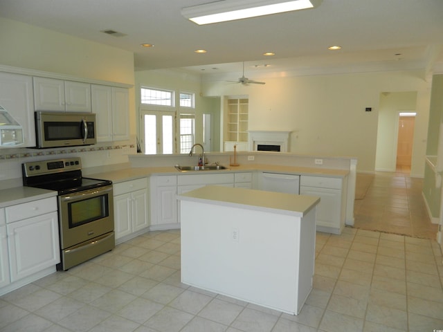 kitchen with stainless steel appliances, a center island, sink, and white cabinets