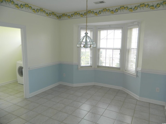 unfurnished dining area featuring washer / clothes dryer and light tile patterned floors